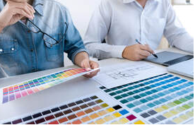 Dos hombres en Granby están mirando las paletas de colores. Hay un plano del arquitecto sobre la mesa.